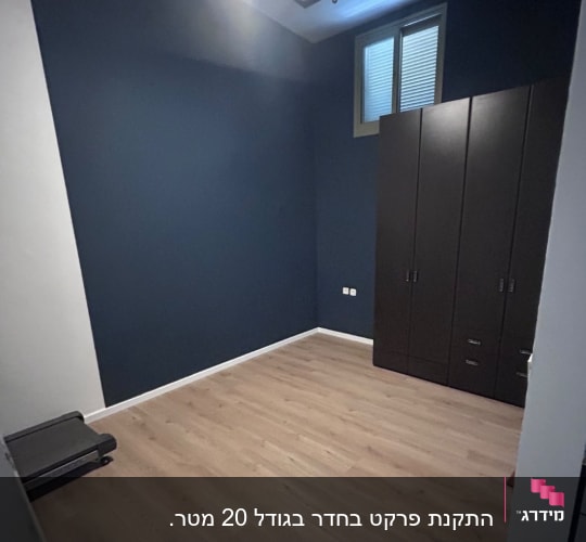 חדר עם רצפת פרקט, ארון וחלון קטן